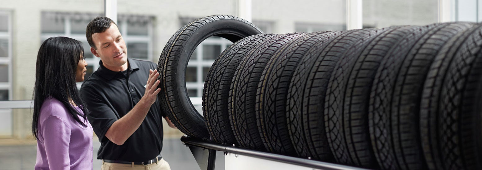 Subaru service representative showing customer a tire. | Romeo Subaru in Saratoga Springs NY